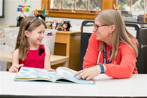 A DPS student and teacher read together. 